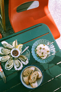 Fresh oysters and baguette slices on green table