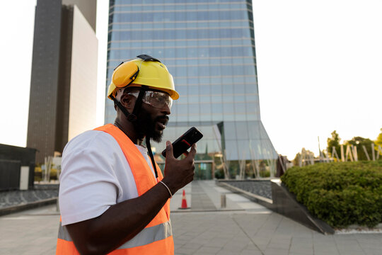African american construction worker communicating with mobile phone