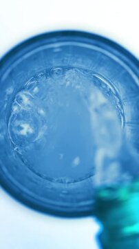 Pouring fresh pure sparkling water from bottle into a glass
