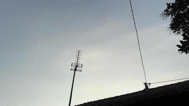 Silhouette Rooftop Antenna Against Clear Evening Sky