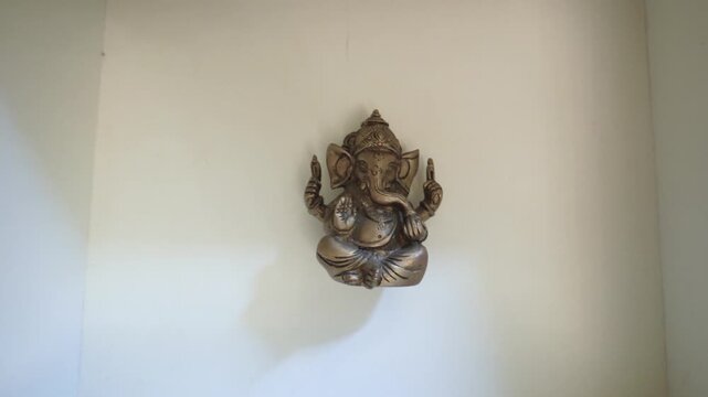 Hands hiding a Ganesha statue. Hindu god figurine being concealed. Secret and safekeeping concept video.