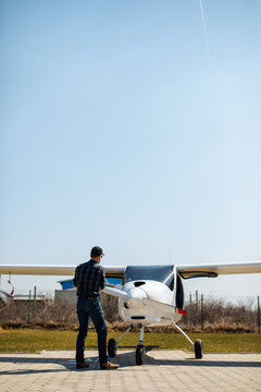 Pilot Performing Preflight Check On Small Airplane