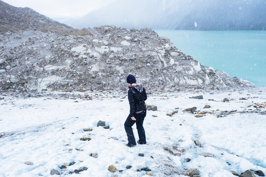 Hiker In Falling Snow By Glacier