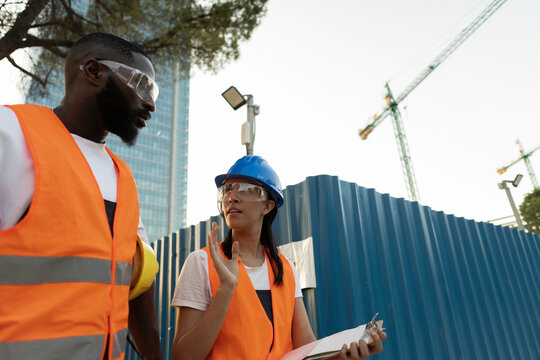 Construction workers discussing project on urban building site