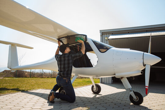 Pilot Cleaning Small Plane During Preflight Inspection