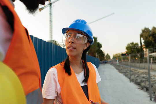 Female construction worker talking discussing project at site