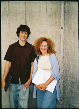 Two people stand together in the university building.