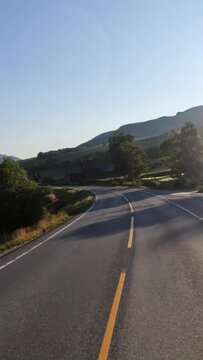 Driving a Car on a Road in Norway at dawn.