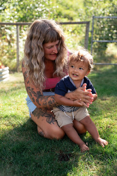 Candid mother and toddler playing in sunny backyard with love