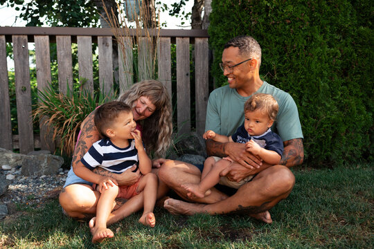 Candid family moment: parents with two young children in backyard
