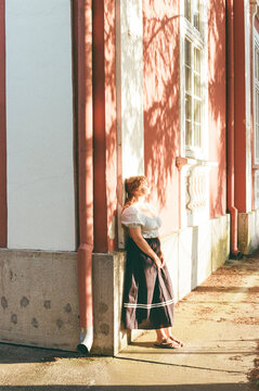 Woman Standing by Building in Afternoon Light