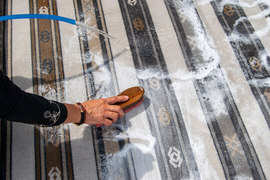 Woman Hand Scrubbing Carpet With Brush And Soap Foam