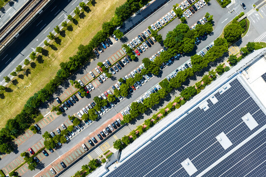 tree-lined parking lot beside solar rooftop factory