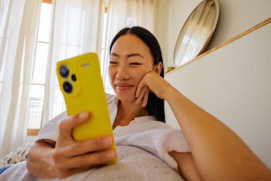 Woman smiling while viewing content on mobile phone