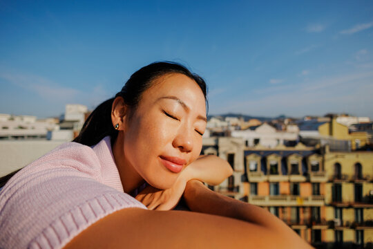 Woman relaxing with closed eyes enjoying city view
