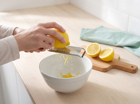 Zesting Fresh Lemon over Mixing Bowl with Fine Hand Zester