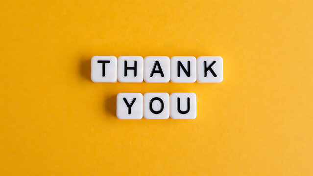 Thank you spelled out with letter tiles on a yellow background