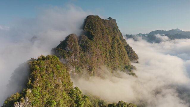 Aerial view of the lush green mountain peaks of Khao Sok National Park rising above a sea of clouds in Surat Thani, Surat Thani, Thailand.
