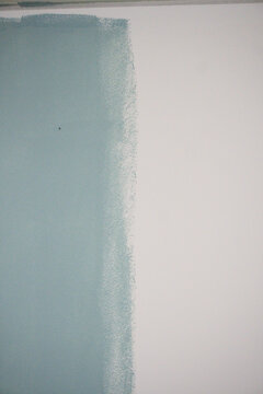 Blue paint strip on white wall below ceiling, roller texture edge, vertical