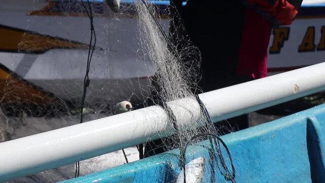 Fisherman's hands rolling up the fishing net