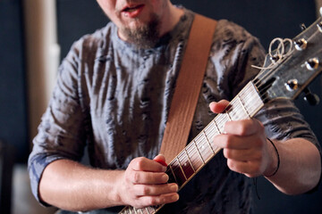 Young male guitarist playing electric guitar during studio rehearsal © TRAVELARIUM