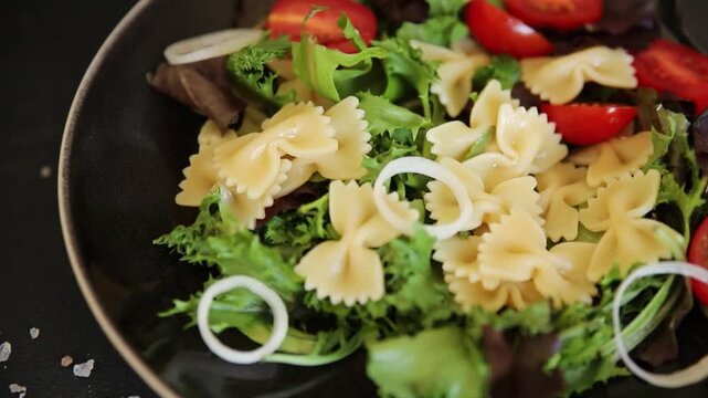 Pasta Salad tomato, green lettuce, farfalle pasta serving size vegetarian and vegan food natural ingredients healthy eating, wholesome tasty dish, snack fresh, gourmet, rustic food background on the t