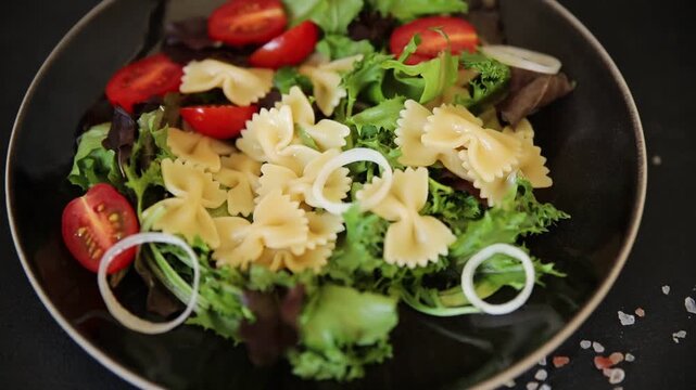 Pasta Salad tomato, green lettuce, farfalle pasta serving size vegetarian and vegan food natural ingredients healthy eating, wholesome tasty dish, snack fresh, gourmet, rustic food background on the t