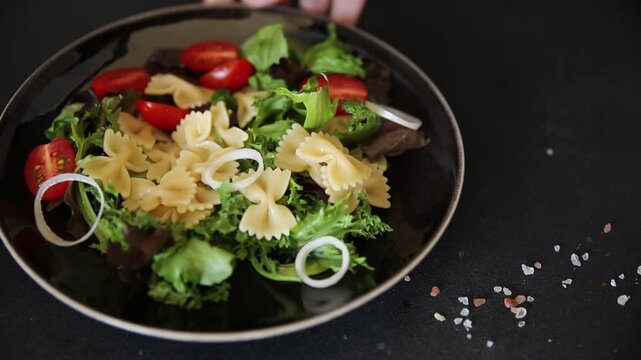 Pasta Salad tomato, green lettuce, farfalle pasta serving size vegetarian and vegan food natural ingredients healthy eating, wholesome tasty dish, snack fresh, gourmet, rustic food background on the t