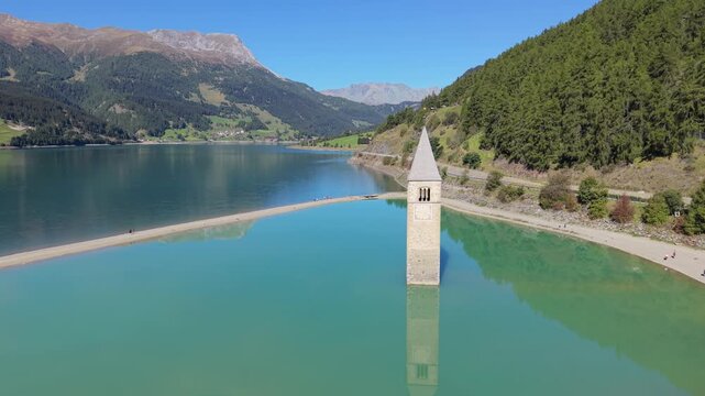 Drone approach to the bell tower in Lake Resia, South Tyrol, Italy