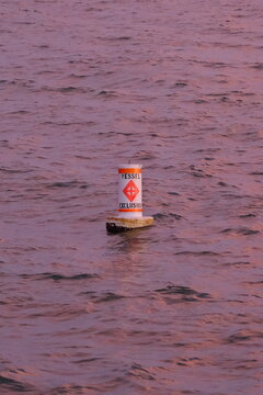 White vessel exclusion marker buoy floats in rippled water reflecting