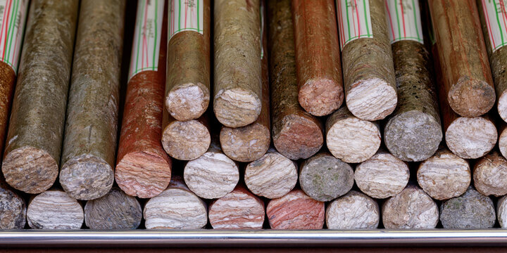 Stacked cylindrical geological core drill samples showing varied rock layers and colors