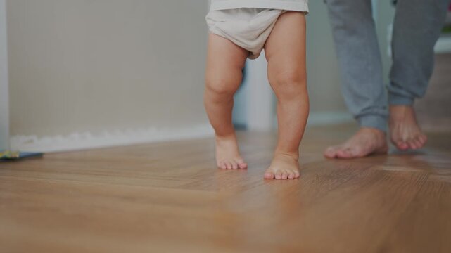 baby first steps. happy family kid dream concept. father teaches baby daughter to take first steps at home lifestyle in front of window. father's day concept. baby takes his first steps