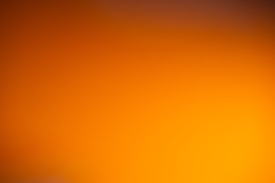 Abstract orange and amber gradient background with softly blended warm tones and subtle dark edges, vibrant colorful backdrop for graphic design
