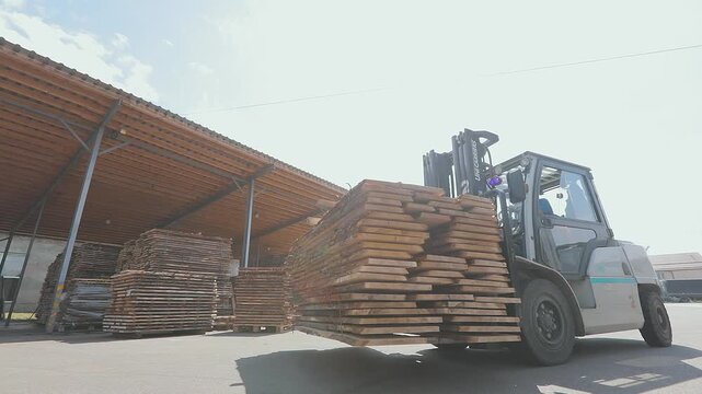 Storage and drying of wooden boards in an open area in the furniture factory yard. Storage yard of a furniture factory, sawmill, or woodworking plant.