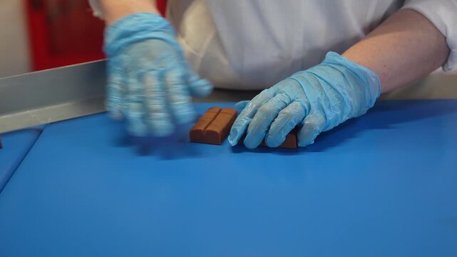 Chocolate Candies Process Making Master Factory Worker. confectionery plant industry. Toffee candy on the shelves. The conveyor for the production of chocolate factory