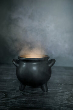 Smokey glowing cauldron on dark spooky backdrop with copy space, perfect for Halloween flyer