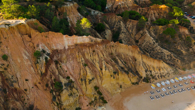Falesia Beach, Algarve, Portugal. Golden mile beach with orange rocks, golden sand and turquoise sea. Aerial drone top view perspective. Famous travel destination in south of Portugal 