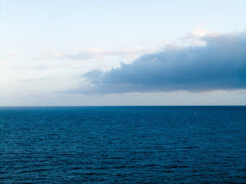 Aerial view of the vast blue ocean off the coast with soft clouds drifting across the horizon at Dee Why, New South Wales, Australia.