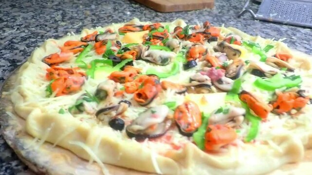 Seafood pizza. Gourmet seafood pizza topped with mussels, tomatoes. Crispy seafood pizza with mussels and cheese. Italian pizza with seafood closeup. A man cooks pizza in the oven. 4K.