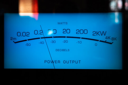 Analog power meter on stereo amplifier showing audio watts and decibels, audiophile hifi equipment with illuminated blue display and precision measurement scale