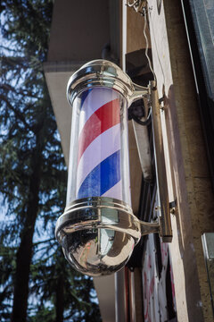 Barber pole outside barbershop, striped retro sign for haircut, grooming salon and traditional local business representing classic barber craft