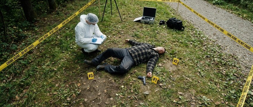 Crime Scene Investigation Forensic Expert Examining Deceased Body Marked with Evidence Markers in Outdoor Setting