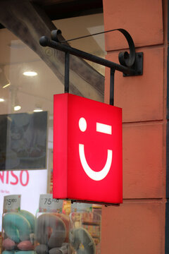 Bright red square outdoor illuminated hanging signboard with the white winking face logo of Miniso store at Vinpearl Harbor in Nha Trang, Vietnam on January 27, 2026.