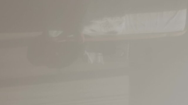 Tossing and turning person in bed at night, struggling with restless sleep. High angle shot capturing the concept of insomnia or a bad dream