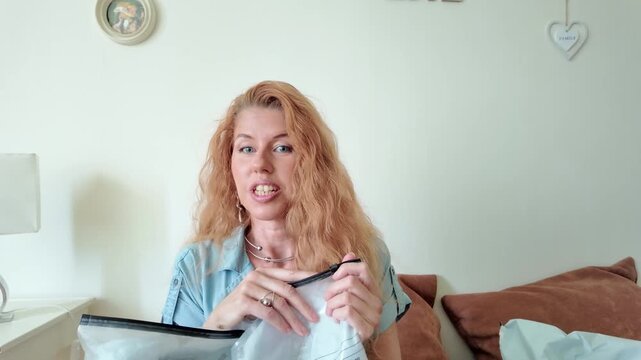 Hesitant Woman Opening Plastic Package and Covering Her Eyes