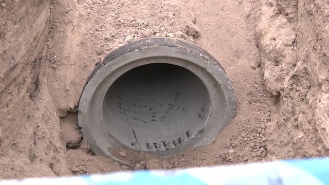 Concrete drainage pipe. Concrete waterproof pipes installed .Construction site Infrastructure of urban sewer engineering networks and lines. Closeup - a round concrete drainage pipe on the ground