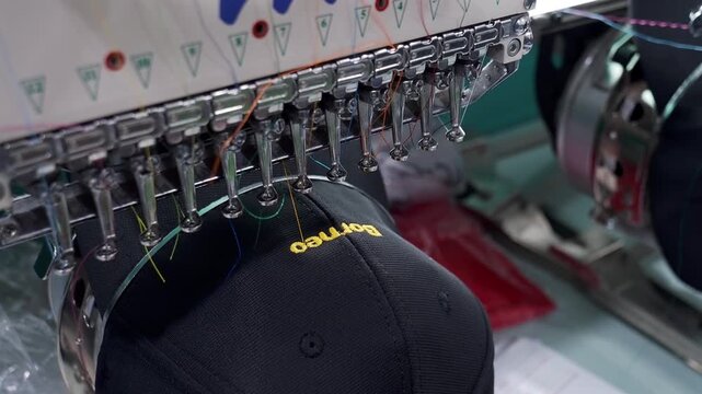 Embroidery machine in progress embroidery company logo on uniform in Textile Industry at Garment Manufacturers.