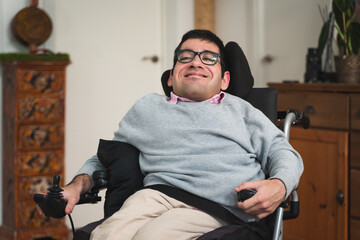 Happy young man in a power wheelchair smiling at home © Lorenzo Capunata