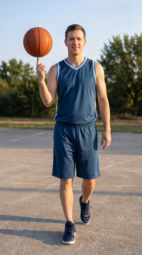 Basketball player spinning ball on outdoor court