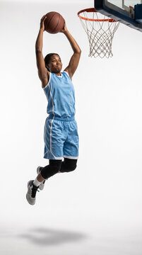 Female basketball player dunking